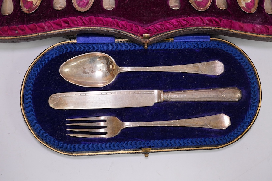 A cased Edwardian silver Christening trio, by Henry Wigful, Sheffield, 1909 and a cased set of eleven Edwardian silver coffee spoons and pair of sugar tongs, London, 1901/2 and one odd silver golf related teaspoon. Condi